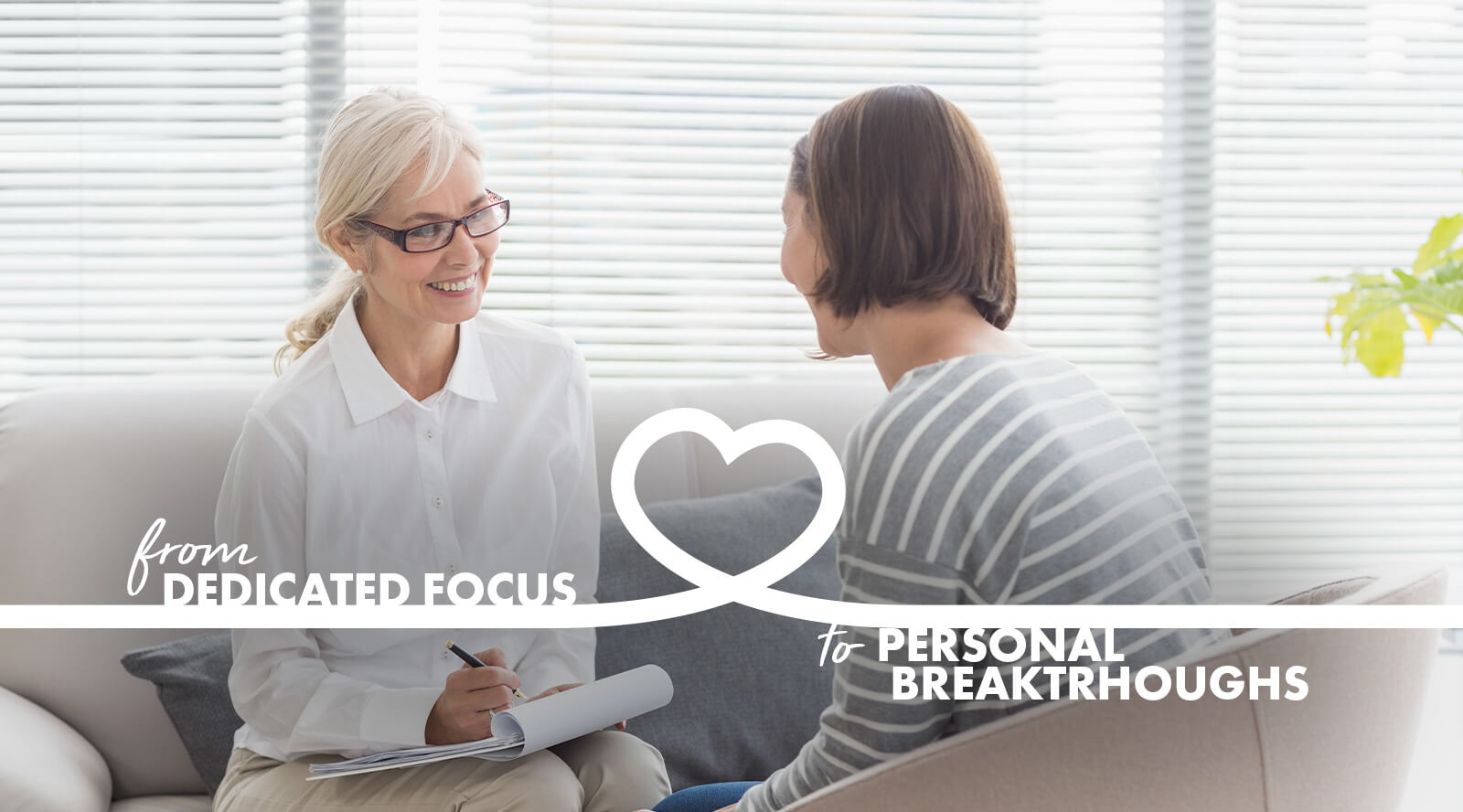 image of a woman therapist smiling and talking with a woman while writing in a chart