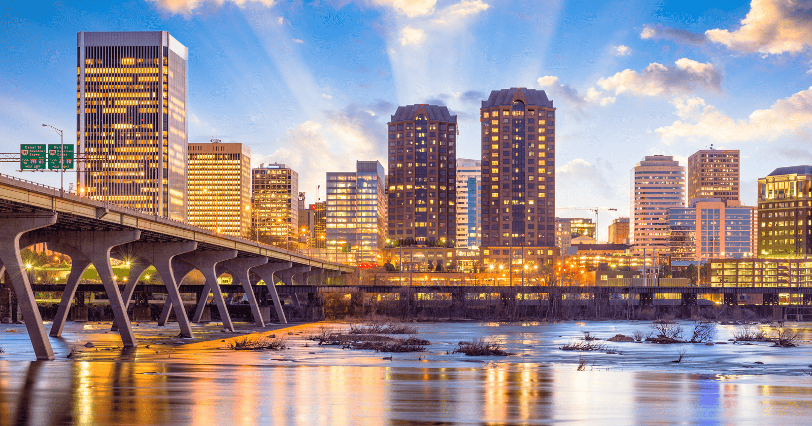 A city skyline with a bridge over water.