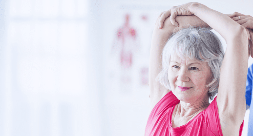 image of a nurse helping an elderly woman exercise her arms and shoulders.