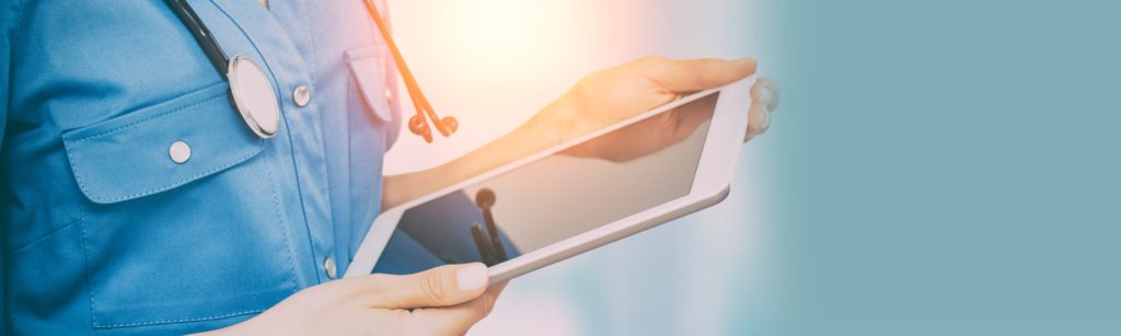 Baanner: Close up image of a tablet being held by a nurse