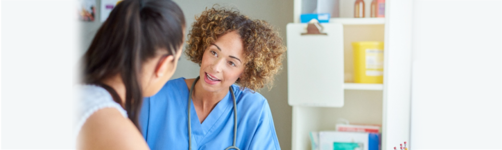 Image: Woman nurses talking to patient about patient safety