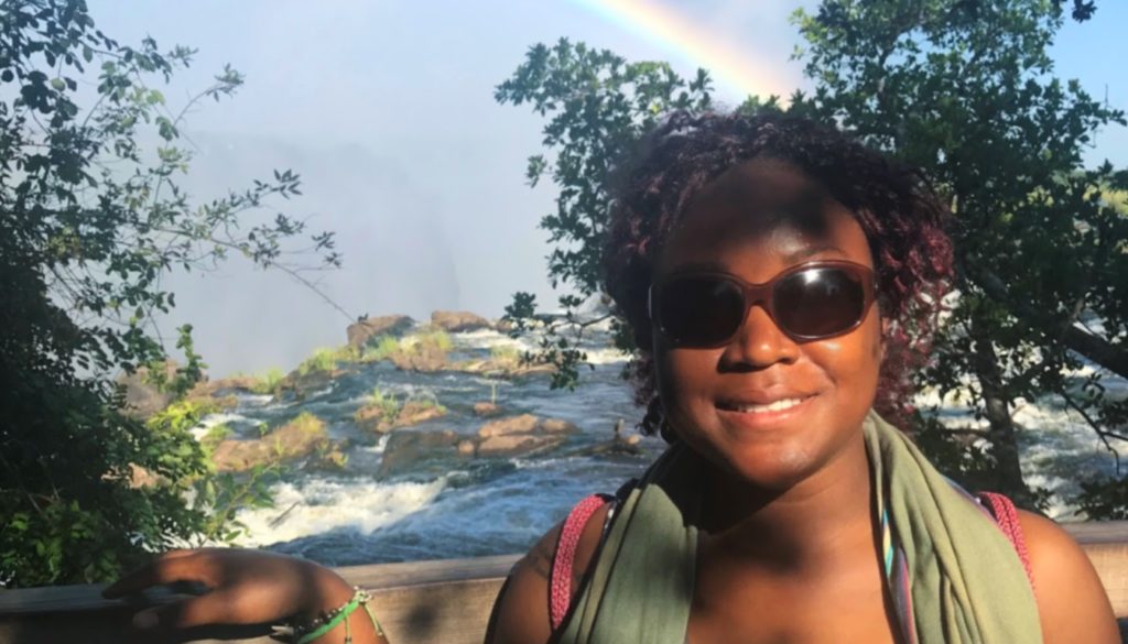 Photo of healthcare worker Linda Gaye outdoors posing for the camera in front of a river