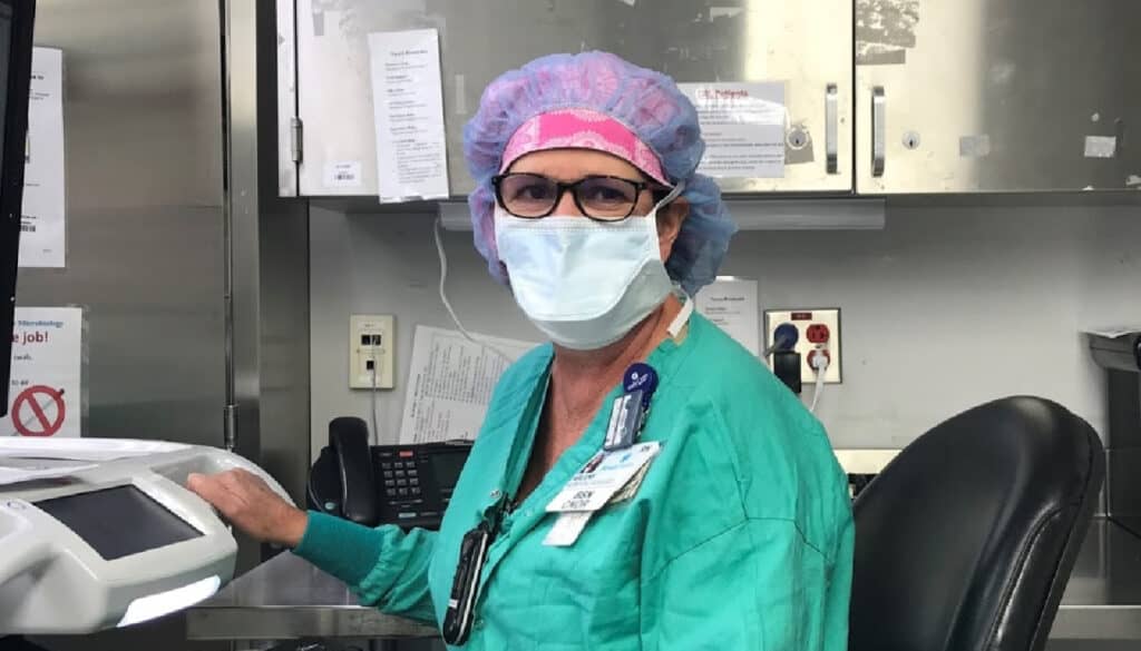 A medical office spotlighting the care and precautions taken by a woman wearing a surgical mask during a long and winding road.