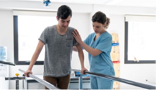 Image of a nurse helping a patient with rehabilitation, celebrating National Physical Therapy Month.