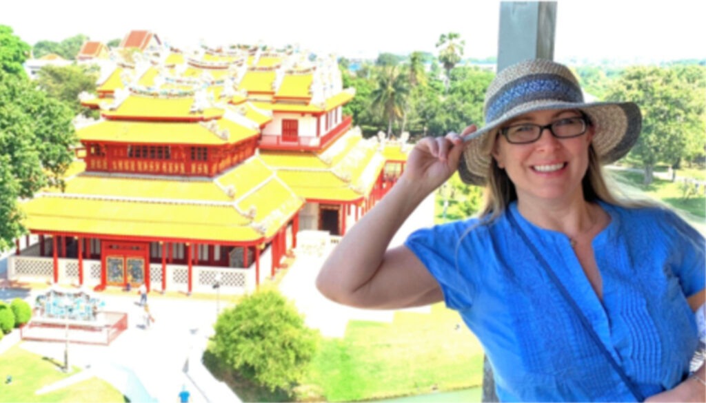 Image: Care More Spotlight: Woman smiling at camera overlooking historical east asian pagoda buildings
