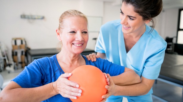 Image of nurse helping a patient with physical therapy