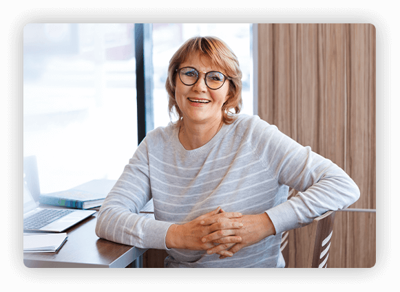 Photo of woman smiling for camera at desk