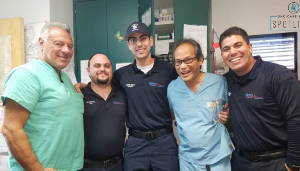 A photo of several healthcare professionals standing with arms interlinked