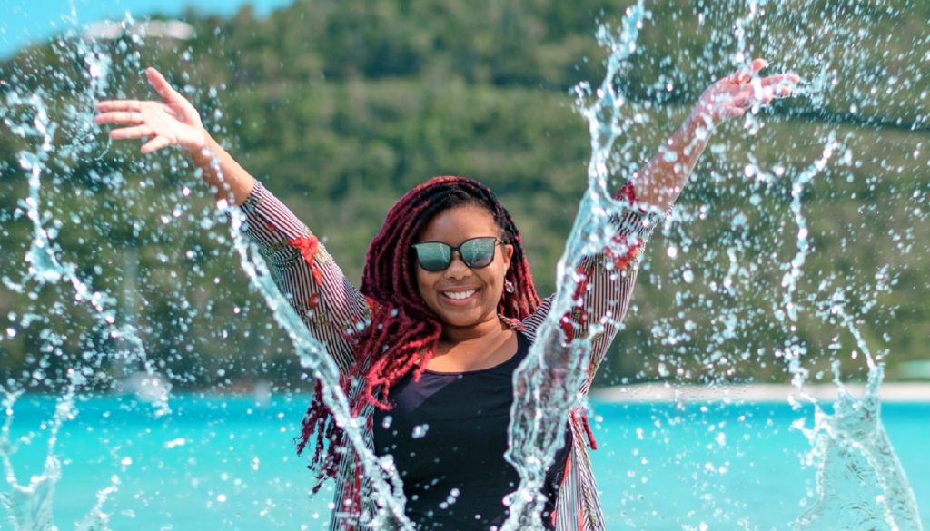 Photo of Donalyn splashing water towards the camera, as she represents traveling SLP therapists