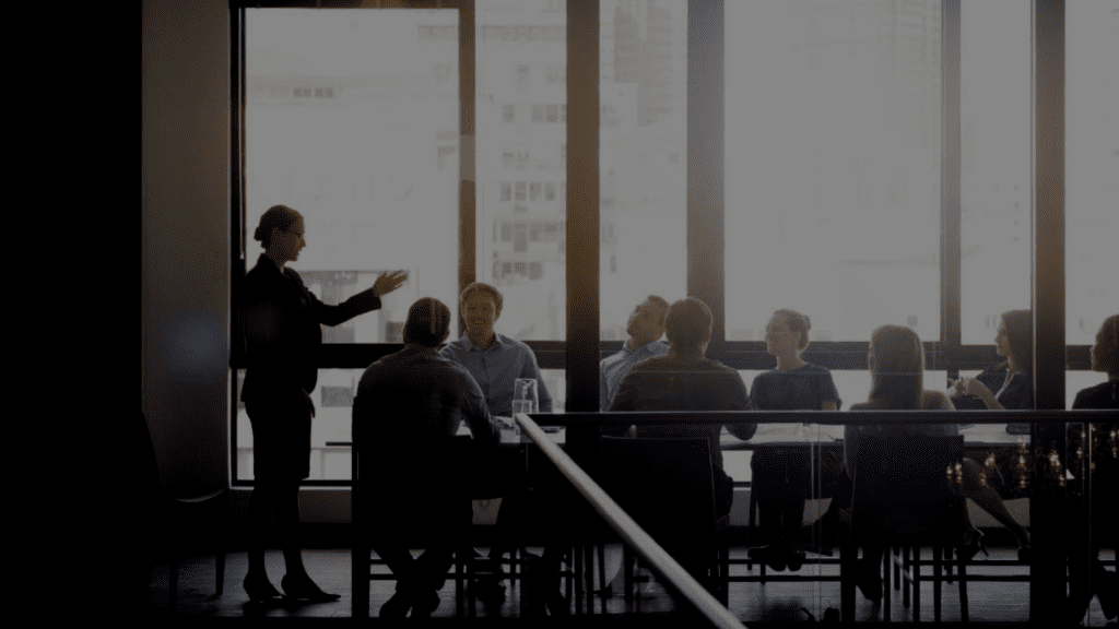 photo of a woman presenting to her company in a conference room