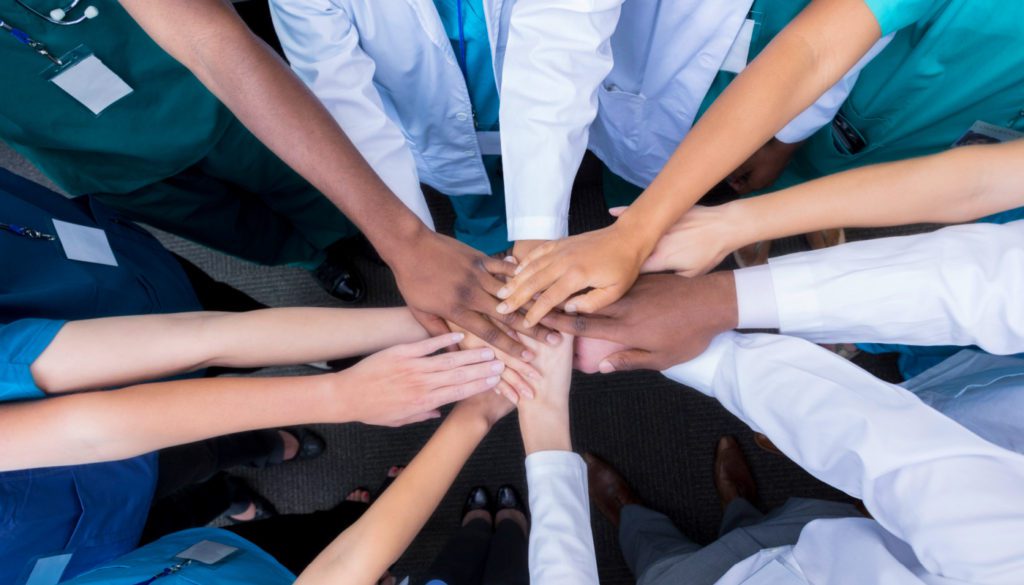 image of multiple hands of many different ethnicities together in a hand stack