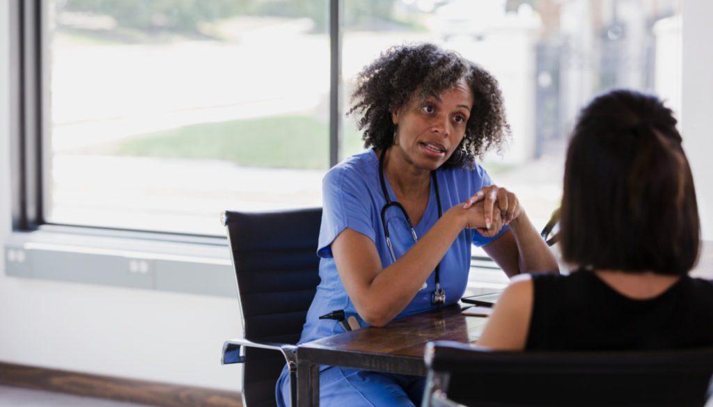image of a black nurse in a serious discussion with another woman