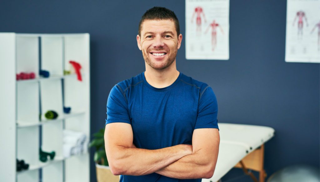 photo of a man smiling with arms folded, The man appears to be a Physical Therapist.