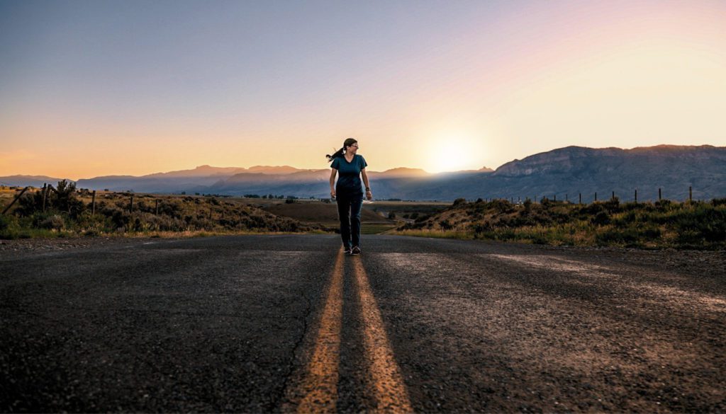 image: medical professional walking down an empty street with the grand canyon in the background
