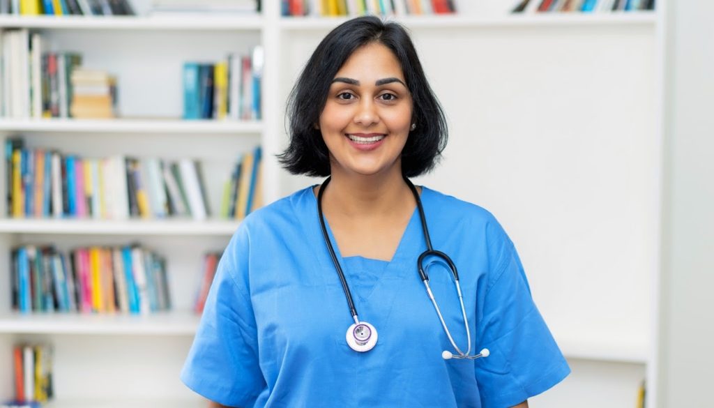 image: medical professional in her scrubs smiling at the camera
