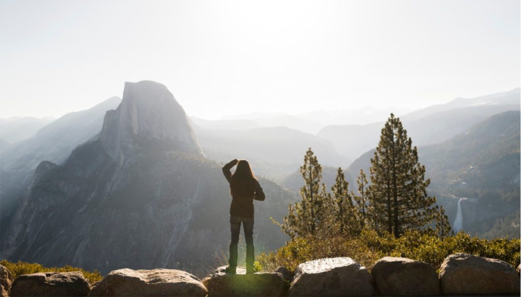 Image: woman overlooking trees and mountains