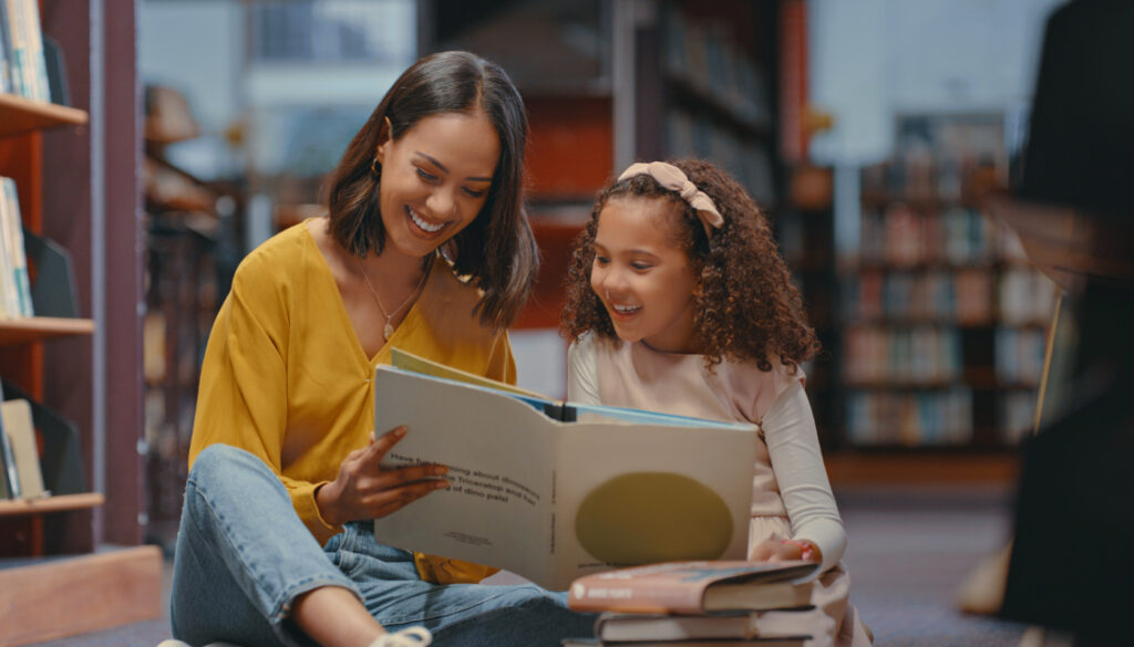Image: Mother reading book with daughter in a library