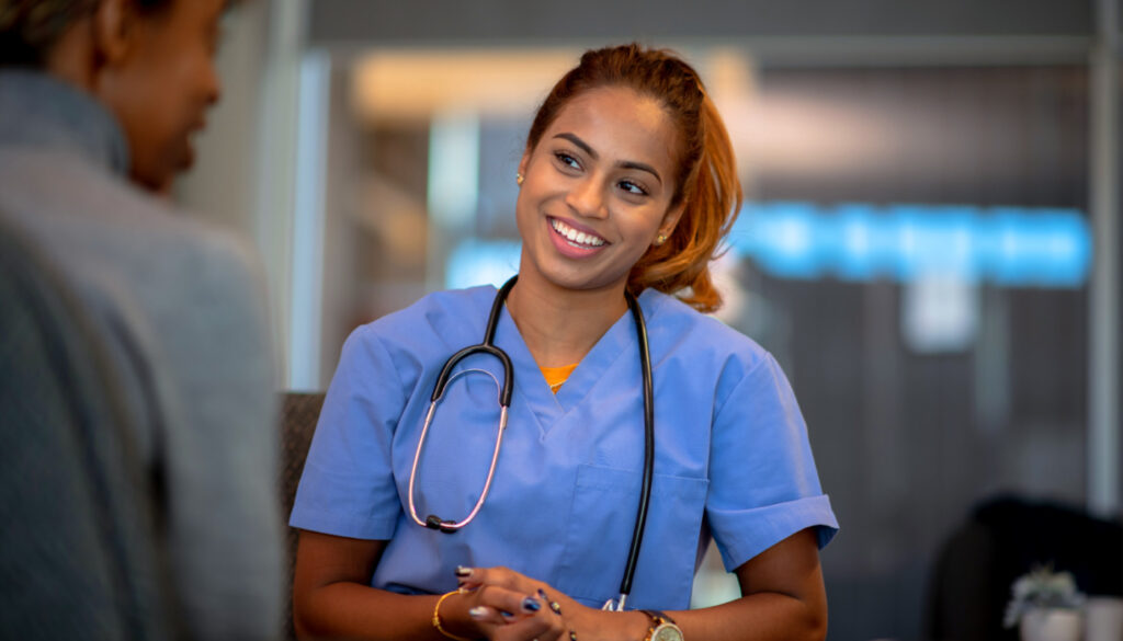 Image: Woman nurse smiling at patient. How to become a nurse supervisor.