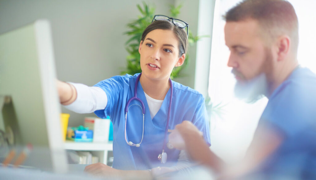 Image: Two nurses considering information on computer screen. Healthcare professionals preparing for the flu season.