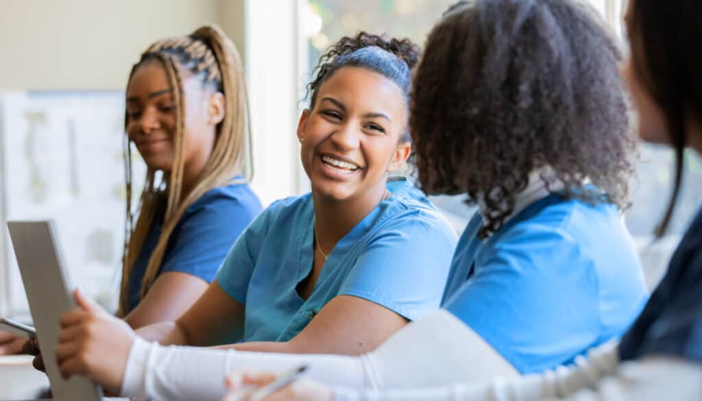 Image: young women nursing students smiling at each other