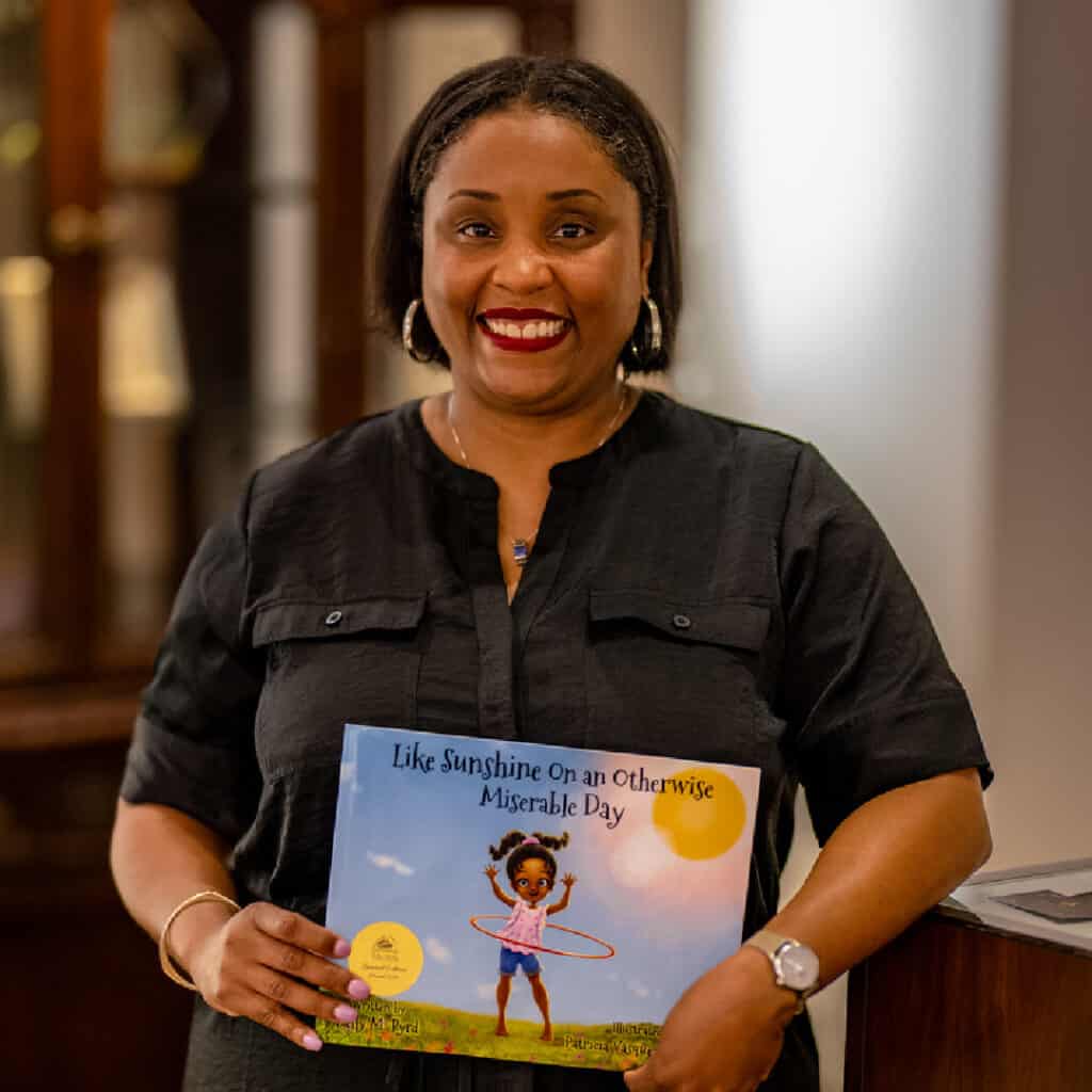 Dr. Kelly Byrd, SLP with her children's book, Like Sunshine onan Otherwise Miserable Day