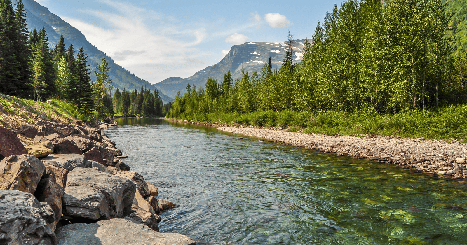 A river surrounded by mountains and trees.