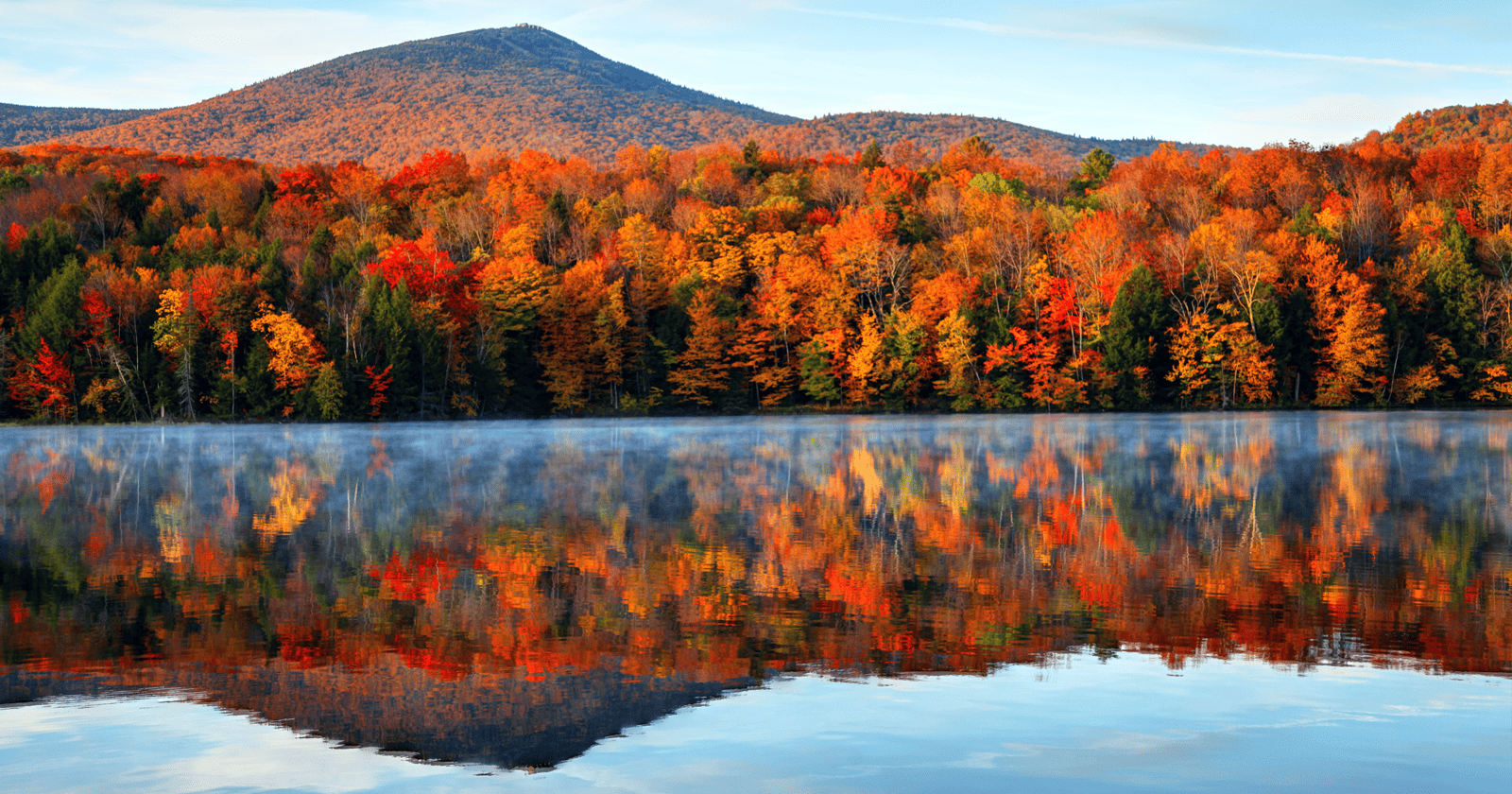 Autumn trees reflected in a lake in Vermont. 