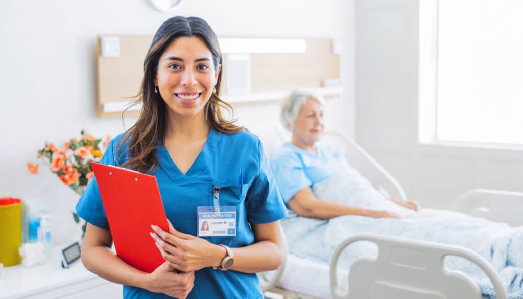 A med-surg nurse standing next to a patient in a hospital bed before surgery.