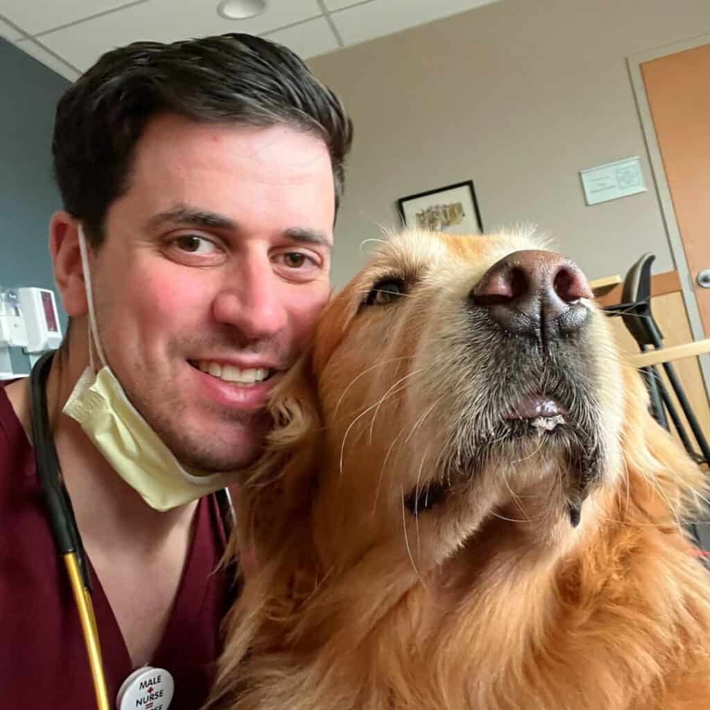 Steven, RN with a stethoscope posing with his golden retriever.