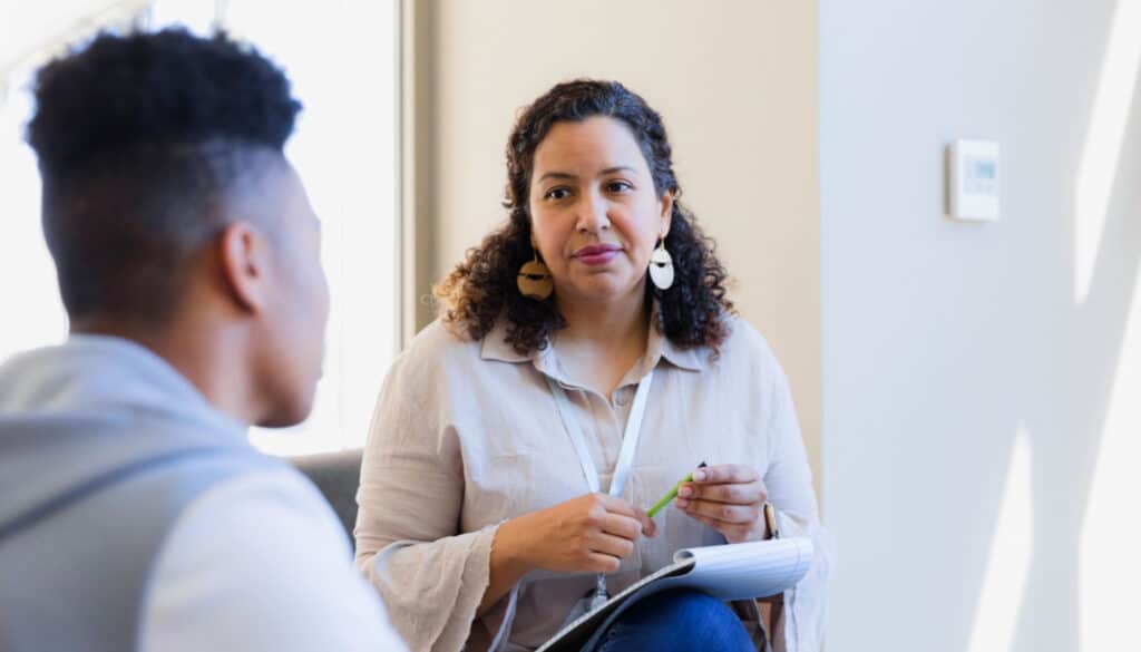 A woman talking to a man in a waiting room.