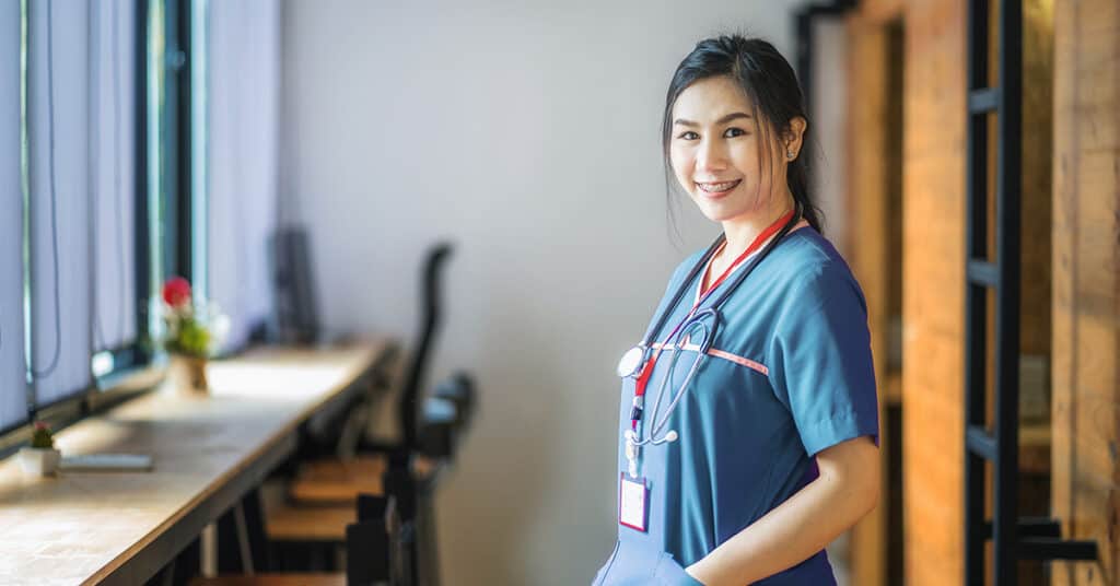 A female nurse standing in a hallway.