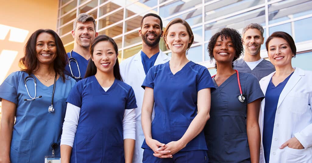 A group of nurses standing in front of a building.