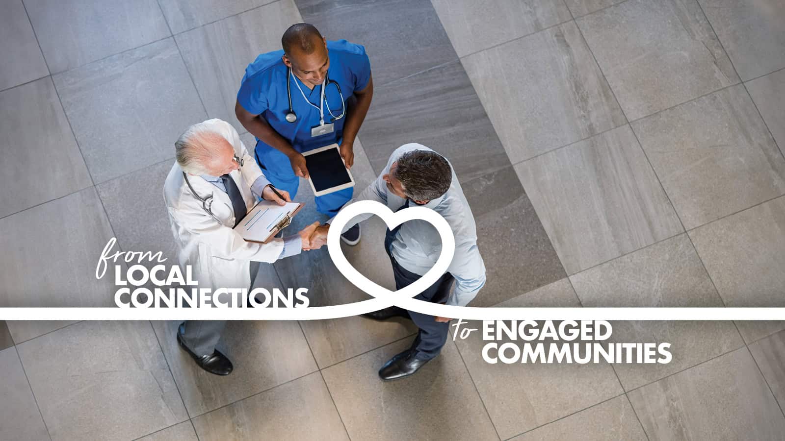 Three healthcare professionals, one standing and two sitting, discuss over a digital tablet in a hospital hallway, with a graphic stating "from local connections to engaged communities. Illustrating the connection of Direct Sourcing programs. 
