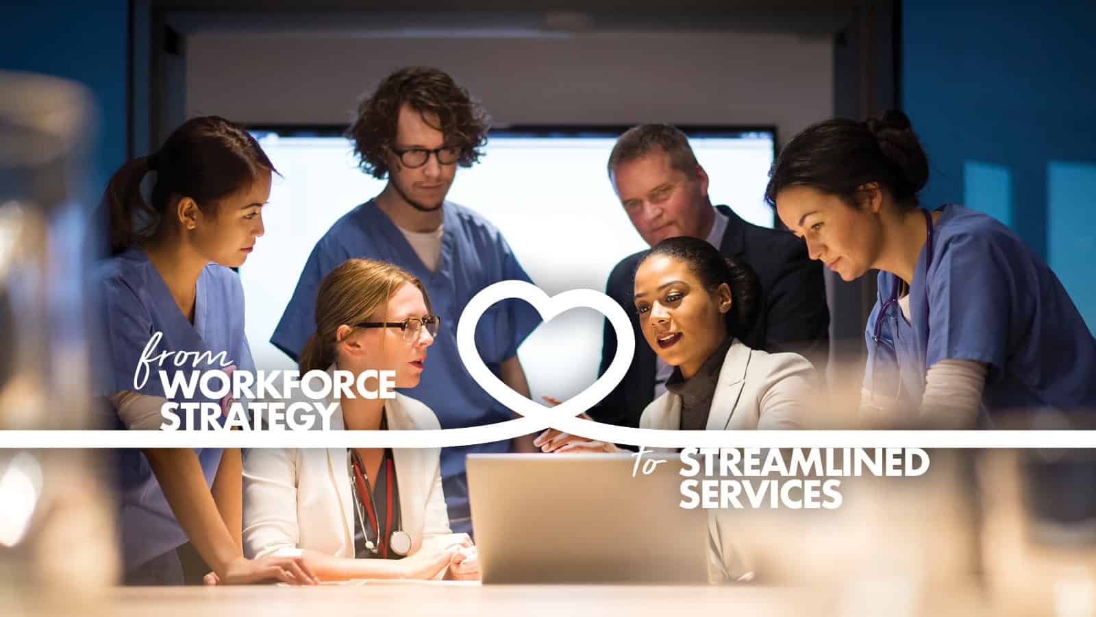 A diverse group of healthcare professionals gathered around a computer in a meeting, discussing strategies for streamlined services.